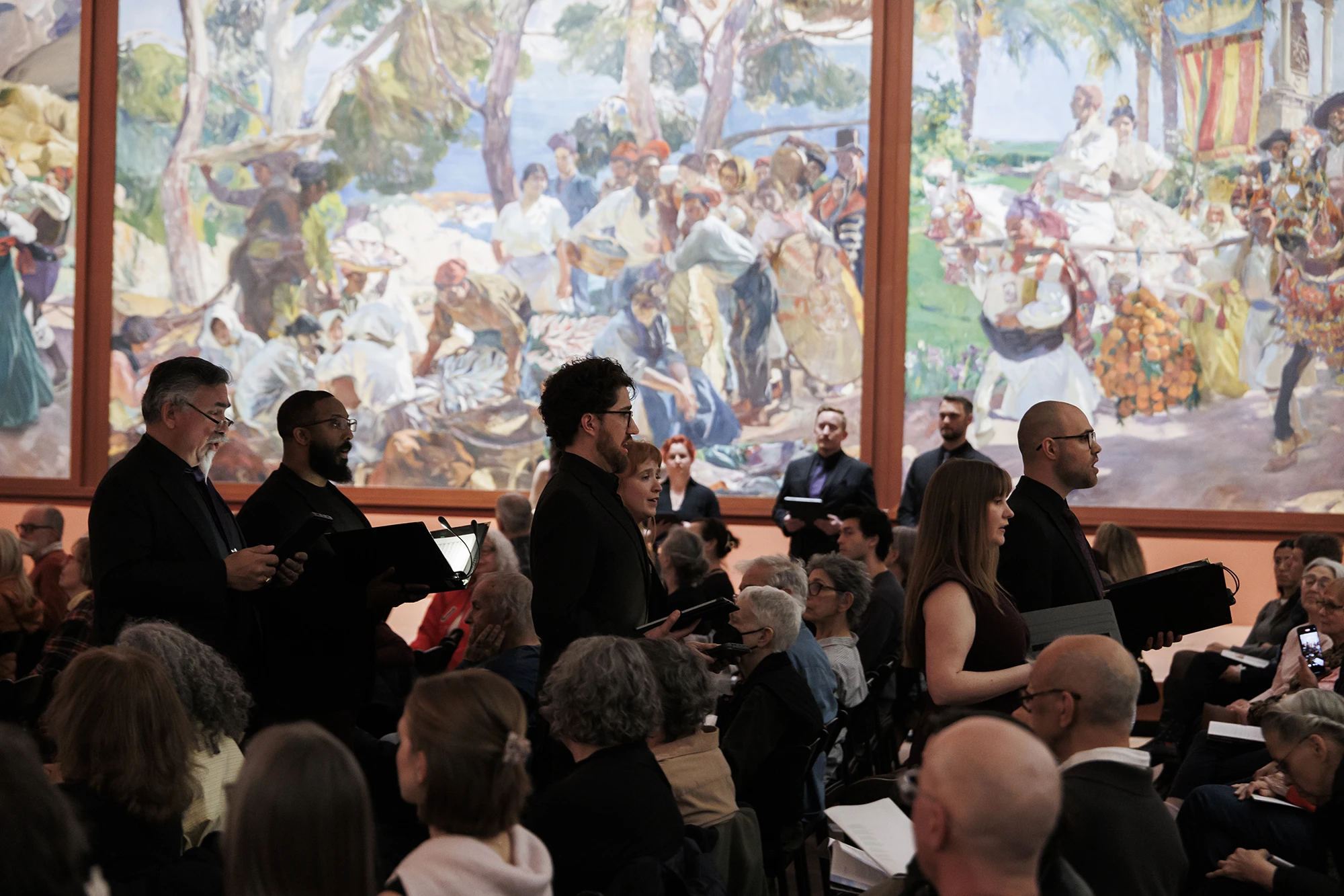 Skylark vocal ensemble walks through the audience against colorful murals by Joaquín Sorolla at the Hispanic Society Museum and Library.