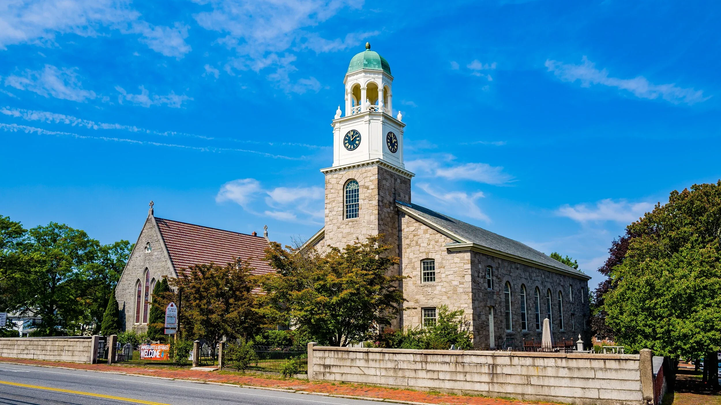 St. Paul's Episcopal Church in Newburyport with a white bell tower and teal copper steeple against a blue sky. Click to purchase North Shore subscriptions.